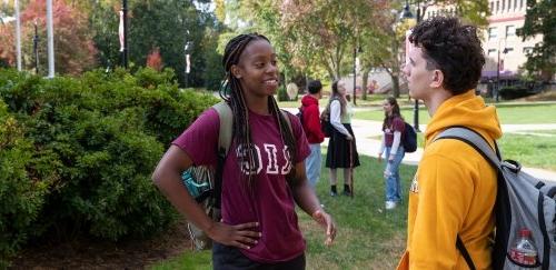 Students talking on campus on a sunny, fall day